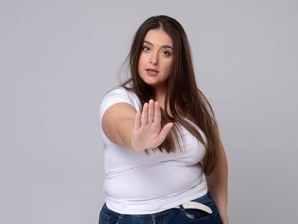 Plus Size Model with long hair gesturing no signal in studio. - Foto, Bild