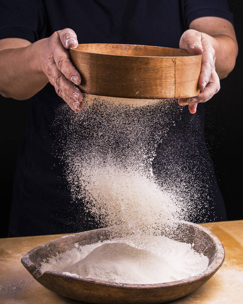 sift the flour for the homemade dough - Foto, afbeelding