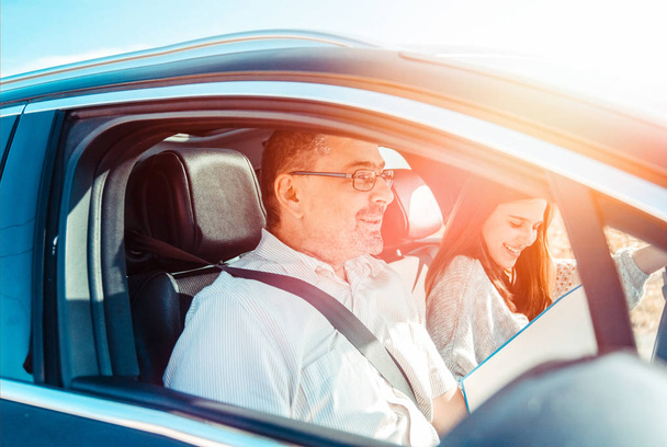 Chica adolescente conduciendo padre en coche por primera vez. Adolescente Mujer y hombre Yendo en un pequeño viaje juntos - Foto, imagen
