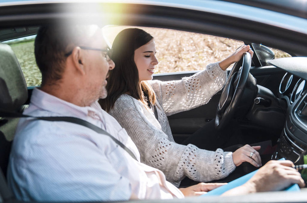 Adolescente en test de permis de conduire, assise sur le siège du conducteur avec l'homme instructeur à l'examen - Photo, image