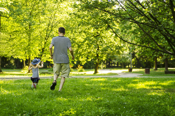Vater und entzückendes Kleinkind Tochter spielen und umarmen im Park - Foto, Bild