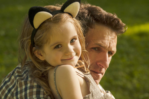 Padre y adorable niña pequeña hija jugar y abrazo en el parque
 - Foto, imagen