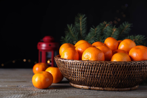 Ripe tangerines on wooden table against dark background. Christmas celebration - Фото, зображення