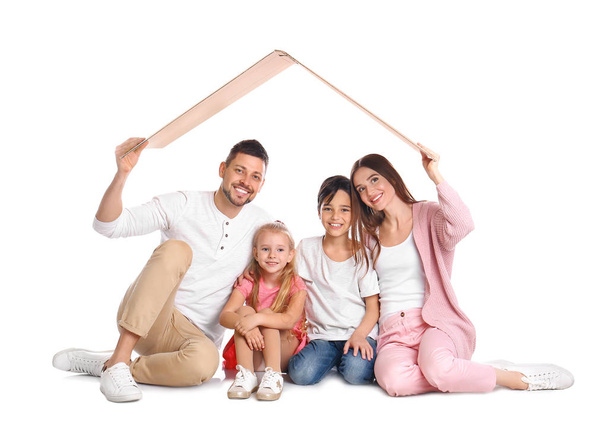 glückliche Familie sitzt unter Pappdach auf weißem Hintergrund. i - Foto, Bild