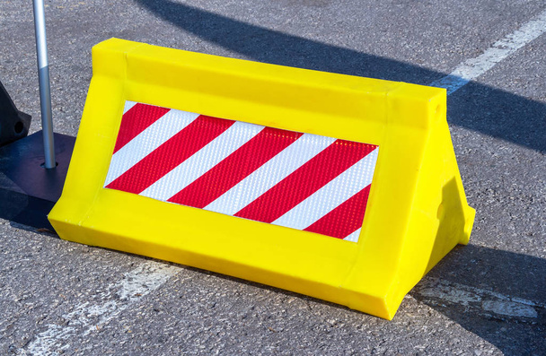 Дорожный барьер с красным и белым полосатым рисунком
 - Фото, изображение