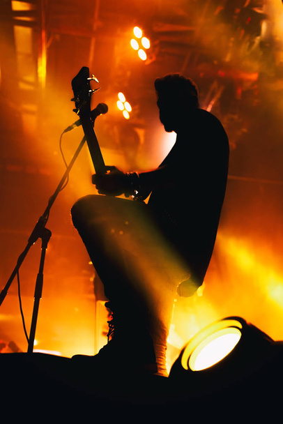 Silhouette of a musician on the stage of a night club. - 写真・画像