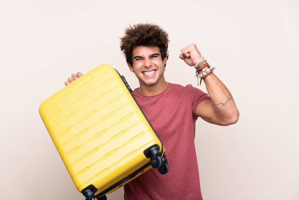 Mladý běloch přes izolované pozadí v dovolené s cestovním kufříkem - Fotografie, Obrázek