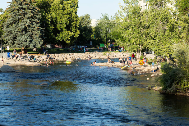 Les gens qui jouent dans la rivière Truckee au centre-ville de Reno en été
 - Photo, image