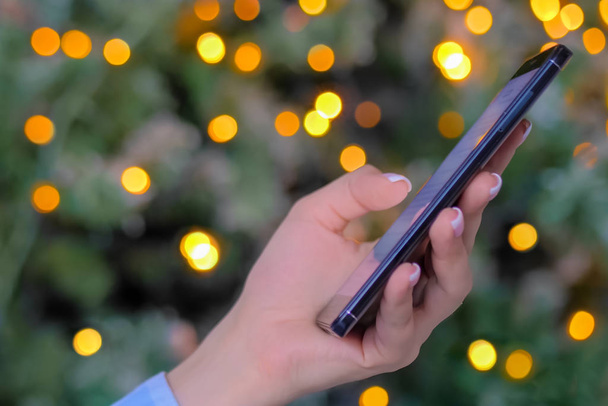 Mujer usando smartphone, fondo de luz de Navidad - de cerca - Foto, Imagen