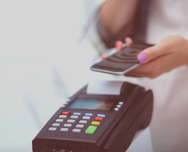 Müşteri ile smartphone Nfc teknolojisi kullanılarak dükkanda ödüyor. NFC teknolojisi. Müşteri ödeme - Fotoğraf, Görsel
