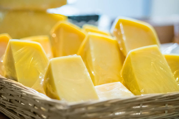 Tezgahta satılık lezzetli el yapımı sarı peynirler. - Fotoğraf, Görsel