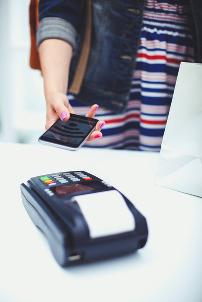 Customer is paying with smartphone in shop using NFC technology. NFC technology. Customer is paying - Foto, Imagem