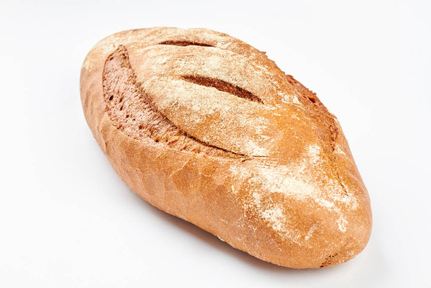 Whole loaf of a crispy bread on white background. - Photo, Image