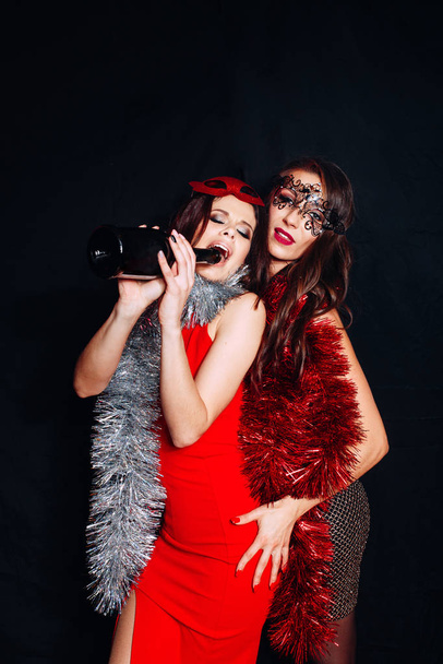 Two sisters enjoying party, having fun, hugging with glasses of wine - Photo, image