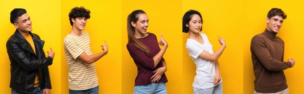 Set of people over isolated yellow background pointing back - Photo, Image