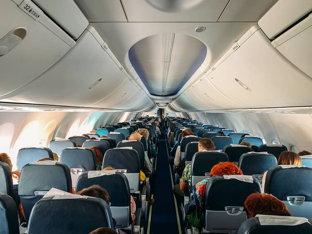 Внутри салона самолета с пассажирами в полете
 - Фото, изображение