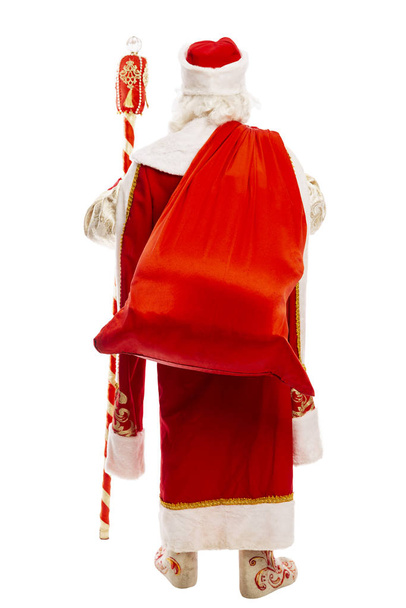 Papá Noel ruso con una bolsa de regalos a sus espaldas. Vista trasera. Aislado sobre fondo blanco
.  - Foto, Imagen