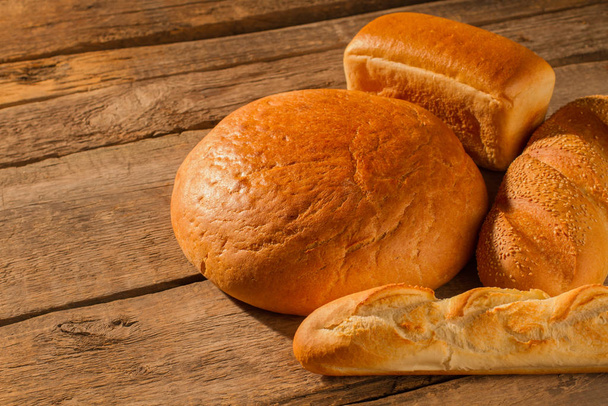 kenyér és sütőipari termékek, fából készült háttér. - Fotó, kép