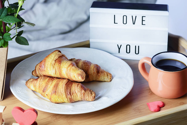 Breakfast in bed. Croissants with jam and coffee. Lightbox with the inscription Love you - Фото, зображення