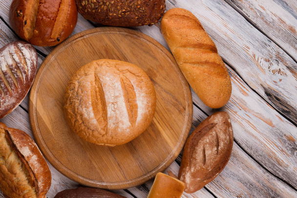 Bread on wooden kitchen cutting board. - Fotó, kép