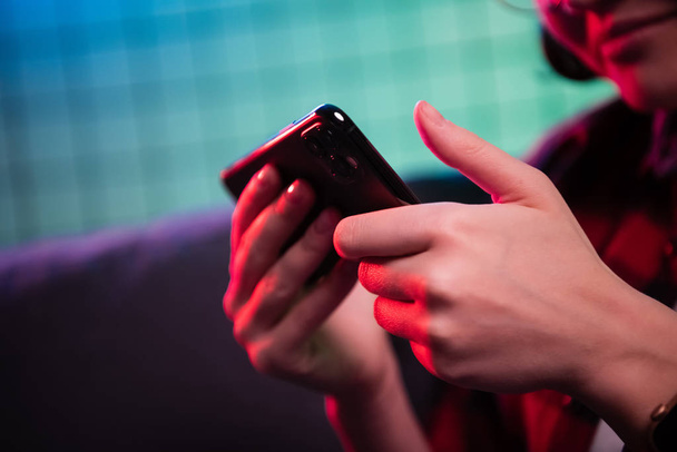 Zbliżenie nastolatka grającego w gry wideo w telefonie komórkowym. Płytka głębia ostrości - Zdjęcie, obraz