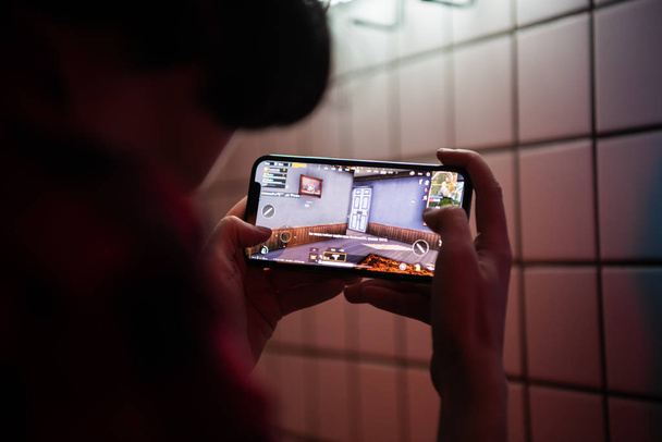 MOSCOW, RUSSIA - December 2019: Closeup of Teenager Playing videogame PUBG On Mobile phone. Shallow depth of field - Фото, изображение