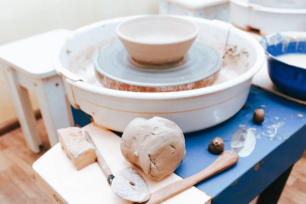Töpfers Arbeitsplatzkonzept. Keramikteller auf einer Töpferscheibe - Foto, Bild