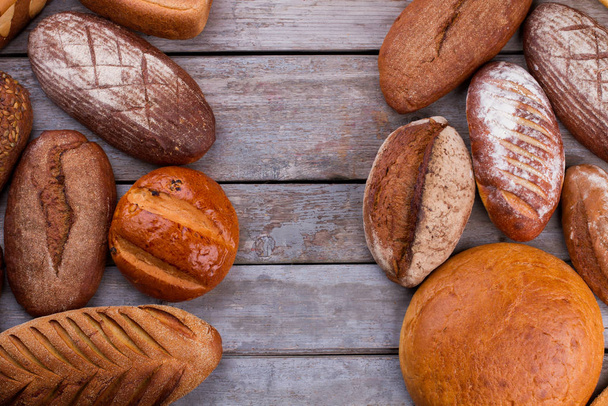 Mixed artisan bread on wooden background. - 写真・画像