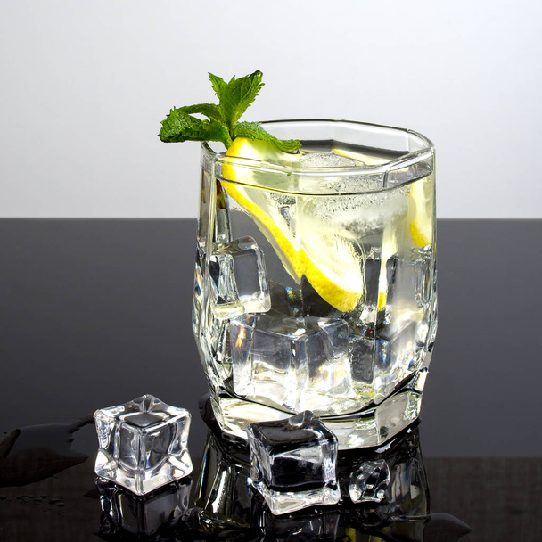 Vodka with lemon and ice on a black background - Zdjęcie, obraz