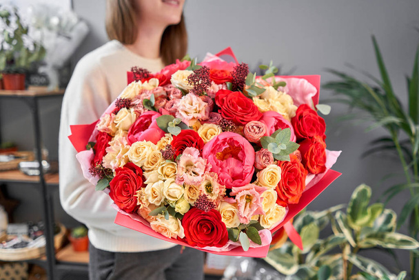 Toni rossi Bellissimo bouquet di fiori misti nelle mani delle donne. il lavoro del fioraio in un negozio di fiori. Bel bouquet fresco. Consegna fiori - Foto, immagini