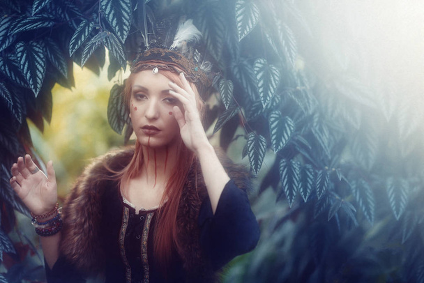 beautiful shamanic woman with headache in the nature. - Фото, зображення