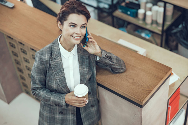 Happy stylish woman with coffee smiling stock photo - Foto, afbeelding