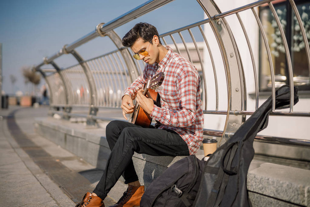 Handsome man musician is playing the guitar - 写真・画像