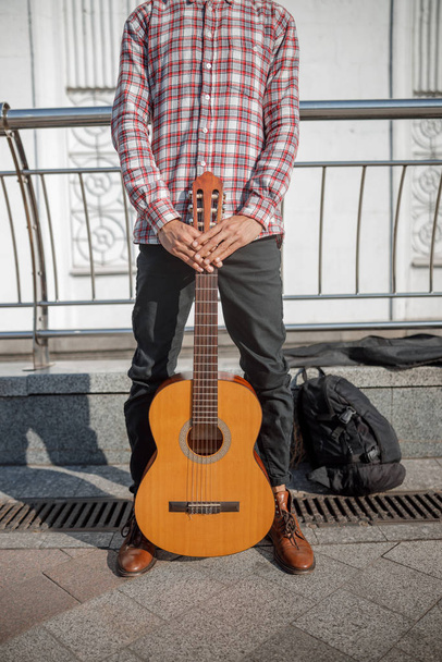 Guitarist standing in the street with his instrument - 写真・画像