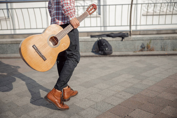 Young guy with guitar walking along the street - Fotoğraf, Görsel