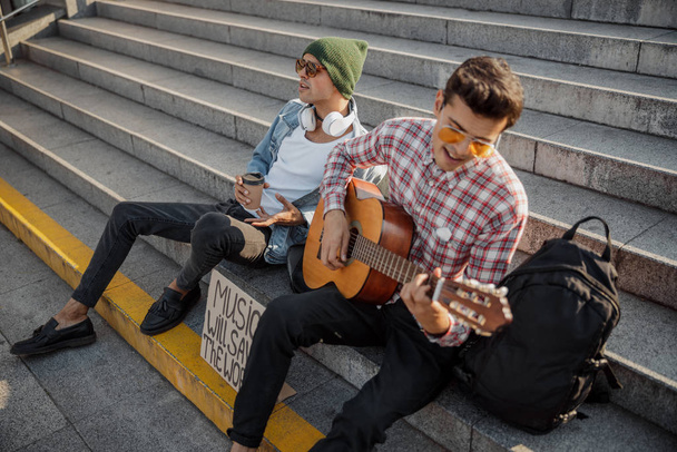 Fiatal zenész lelkesen gitározik az utcán - Fotó, kép