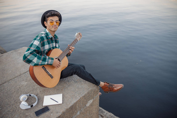 Smiling young musician looking at camera outdoors - Φωτογραφία, εικόνα
