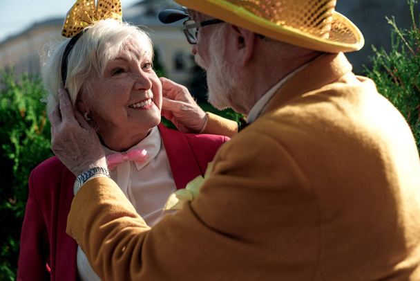 Caring elderly man with wife in funny clothes stock photo - 写真・画像