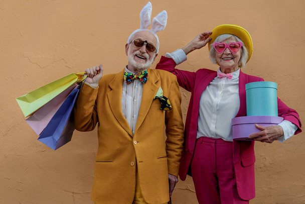 Szczęśliwa para dojrzałych z prezentami w śmiesznych kostiumach - Zdjęcie, obraz