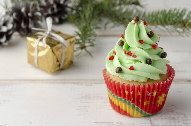 クリスマスツリーで飾られたホイップクリームとクリスマスグリーンカップケーキ - 写真・画像