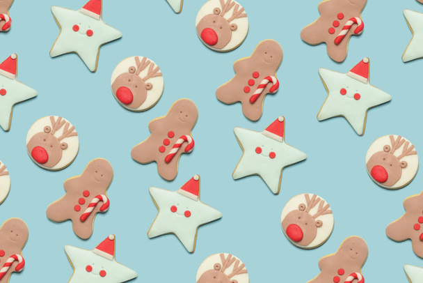 Επίπεδη lay μελόψωμο Χριστουγεννιάτικα μπισκότα σε μπλε φόντο, Χειμερινές διακοπές διακοσμημένα μπισκότα, χαριτωμένα βασιλικά cookies παγοποίησης αδιάλειπτη μοτίβο - Φωτογραφία, εικόνα