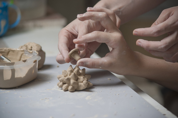 Дівчина робить іграшку з глини
 - Фото, зображення