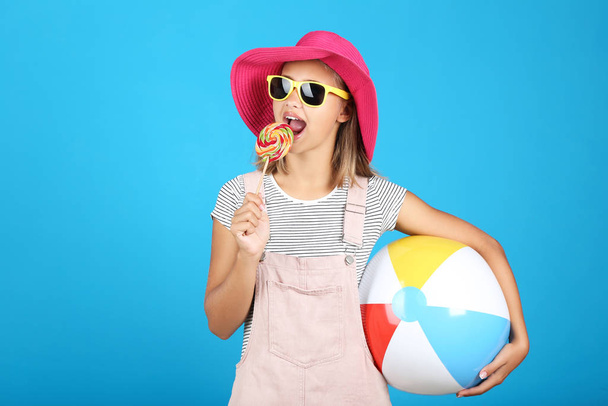 Young girl wearing sunglasses, hat and holding lollipop and infl - Фото, зображення