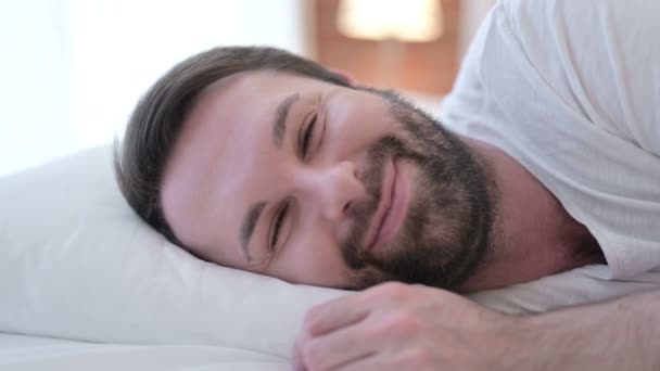 Nahaufnahme von attraktiven Bart junger Mann Video-Chat im Bett  - Filmmaterial, Video