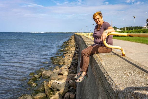 Kypsä pullea nainen lepää Itämeren rannikolla
  - Valokuva, kuva