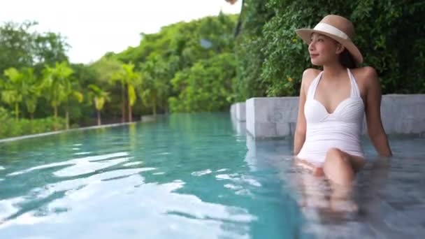 footage of Asian woman relaxing in pool during summer vacation - Filmagem, Vídeo