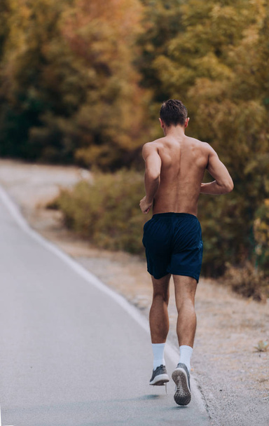 Juokseva mies juoksee juoksemassa kuntoa ja terveyttä varten. Koko kehon pituus näkymä sprinter käynnissä kohti kameraa
. - Valokuva, kuva