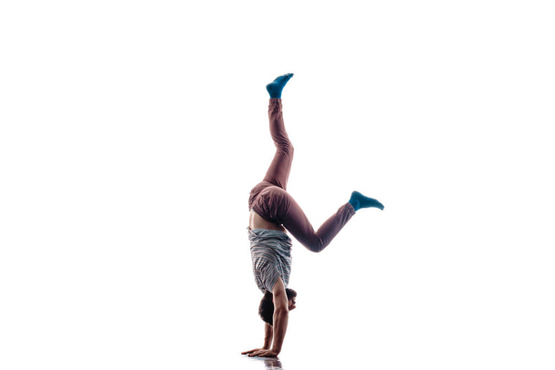 スタイリッシュなダンスムーブメントを行う柔軟な若いダンサー - 写真・画像