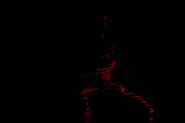 Roter und grüner Laserstrahl Silhouette einer Tänzerin bei modernen Tanzpositionen - Foto, Bild