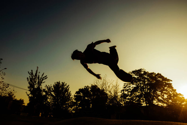 Jól megépített személy, aki parkour mozog a városi gördeszka parkban - Fotó, kép